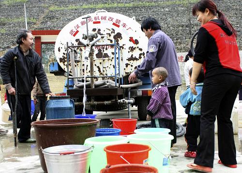 2月2日,廣西河池市東蘭縣泗孟鄉(xiāng)弄平村群眾在接取生活用水。新華社發(fā)(周恩革 攝)