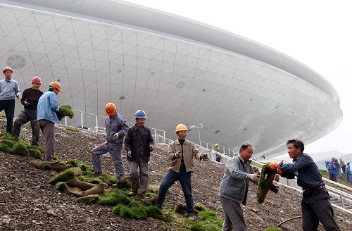 世博文化中心竣工 上海世博會“一軸四館”全部建成 3月31日,工人在搬運鋪設(shè)在文化中心周圍的草皮。 當日,造型呈飛碟狀的上海世博會文化中心正式竣工。至此,上海世博會“一軸四館”五大永久性建筑全部建成。 世博文化中心位于世博園核心區(qū),總建筑面積近16萬平方米,其中地上為單層多功能劇場及環(huán)繞主場館的周邊六層建筑,地下建筑為兩層。世博文化中心的劇場空間可通過靈活的垂直分割系統(tǒng)和可伸縮可升降的觀眾座椅系統(tǒng),根據(jù)需要隔成18000座、12000座、10000座、8000座、5000座等,舞臺可根據(jù)演出內(nèi)容在大小、形態(tài)、甚至在360度空間中進行三維組合,使之既能舉行超大型慶典、演唱會,又能打NBA籃球賽,還能進行冰上表演,甚至冰球比賽。同時,在文化中心里還設(shè)有音樂俱樂部、電影院、溜冰場、世界各國美食街、兒童樂園、汽車文化展示廳以及近2萬平方米的商業(yè)零售區(qū)域。 新華社記者 任瓏攝