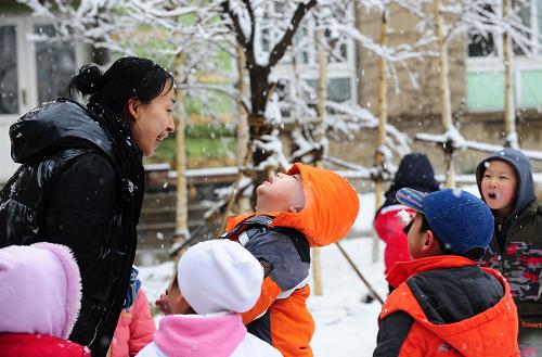 4月9日,沈陽(yáng)市皇姑區(qū)實(shí)驗(yàn)幼兒園的李蕊老師(左一)陪伴中班的小朋友在雪中嬉戲。新華社記者 任勇 攝