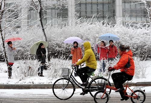 4月9日,在沈陽(yáng)街頭行人冒雪前進(jìn)。新華社記者 李鋼 攝