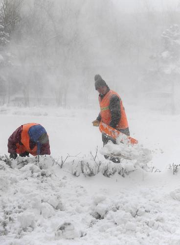 4月13日,環(huán)衛(wèi)工人冒雪清理路面積雪。新華社記者 李勇 攝