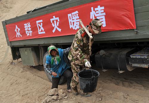 這是送水戰(zhàn)士幫助寧夏西吉縣平峰鎮(zhèn)王慶村村民將水運回家中(4月13日攝)。新華社記者 王鵬 攝