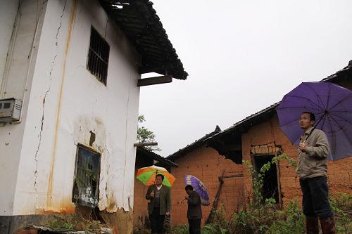 4月14日,在江西贛縣長洛鄉(xiāng)長洛村,工作人員冒雨對村里的危舊老房開展汛期排查。新華社發(fā)(朱建華 攝)