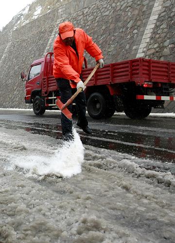 5月17日,養(yǎng)路工人在312國(guó)道烏鞘嶺段拋灑融雪劑。新華社發(fā)(姜愛(ài)平 攝)