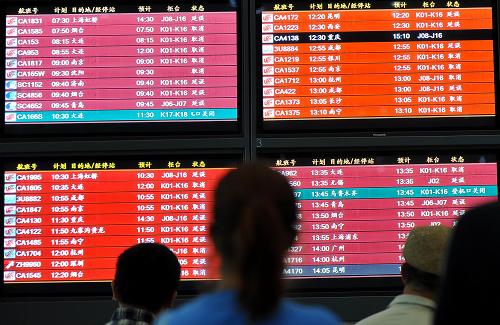 6月17日,乘客在首都機場T3航站樓內(nèi)查看航班消息。新華社記者 羅曉光 攝
