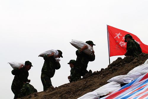 7月8日,揚(yáng)州民兵抗洪隊(duì)員進(jìn)行搬運(yùn)沙袋演練。新華社發(fā)(郁興 攝)