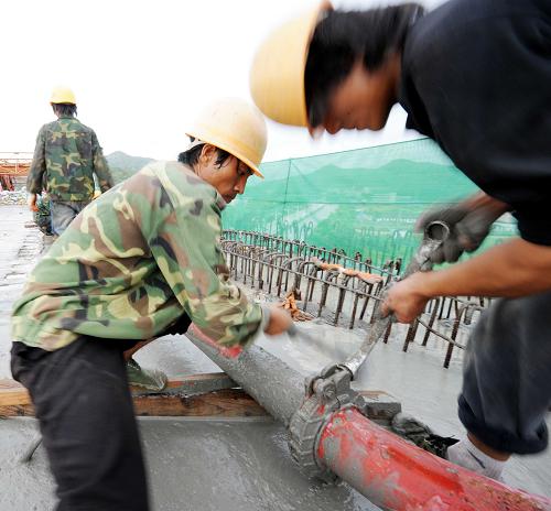 7月22日,中鐵十八局集團(tuán)的建設(shè)者在合龍的東沖特大橋上安裝輸送管道。新華社記者 楊宗友 攝