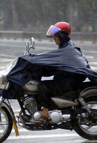 7月22日,一位海口市民在雨中騎行。當(dāng)日,受臺風(fēng)“燦都”外圍影響,海南??诮迪卤┯?,造成??谑袇^(qū)多處低洼和排水不暢路面嚴(yán)重積水,不少車輛在積水中熄火。海南省氣象臺預(yù)報(bào)稱,受“燦都”影響,預(yù)計(jì)未來一天內(nèi),本島北部和東部地區(qū),陰有暴雨,局地特大暴雨,南部地區(qū)陰天有中到大雨,其余地區(qū)有大雨,海南東部、北部沿海陸地將出現(xiàn)7-9級,陣風(fēng)10級的大風(fēng)。新華社記者 侯建森 攝