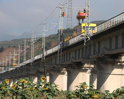 8月22日,在太中銀鐵路呂梁山隧道西口的風(fēng)壕梁大橋上,建設(shè)者架設(shè)電氣化接觸網(wǎng)導(dǎo)線。新華社發(fā)
