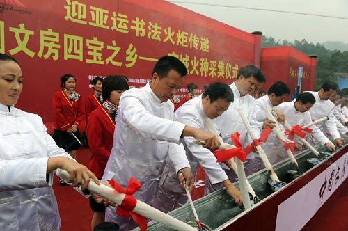 10月14日,宣城市16位非物質(zhì)文化遺產(chǎn)傳承人和書法家在亞運書法火炬?zhèn)鬟f火種采集儀式上點燃文化心愿火炬。新華社記者 王雷 攝