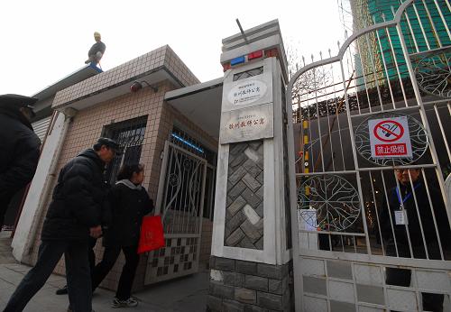 12月20日,上海膠州路失火大樓相鄰大樓的居民走進小區(qū)大門。新華社發(fā)