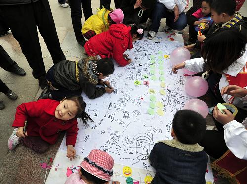 3月20日,在濟(jì)南泉城廣場(chǎng)的“世界水日”宣傳活動(dòng)現(xiàn)場(chǎng),孩子們?cè)诋嬀砩袭嫵鏊麄冃哪恐械?#8220;未來水世界”。新華社發(fā)(崔健 攝)