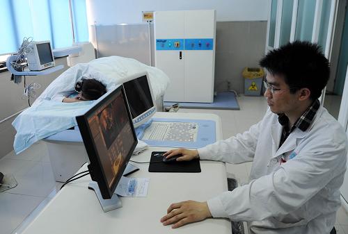 重慶支援崇州的醫(yī)生吳光平在操作“海扶刀”為患者治療(4月20日攝)。新華社記者 陳誠 攝