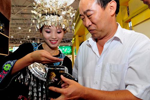 7月8日,在茶博會(huì)上,一位苗族姑娘在給一位市民介紹明前茶。新華社記者 楊楹 攝