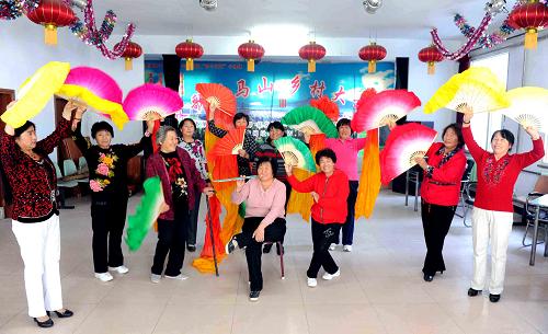 西集鎮(zhèn)居民在文化站排練秧歌(9月23日攝)。西集鎮(zhèn)位于黑龍江省哈爾濱市巴彥縣西部,離哈爾濱市區(qū)75公里。鎮(zhèn)黨委書記李彥國(guó)介紹說(shuō),從2006年起西集鎮(zhèn)開始全面推進(jìn)農(nóng)村文化站建設(shè),并以此為陣地和軸心,輻射全鎮(zhèn),豐富了農(nóng)民文化生活,提升了集鎮(zhèn)建設(shè)品位。重建的西集鎮(zhèn)文化站建筑面積300平方米,配有15000平方米的室外公園活動(dòng)場(chǎng)地,站內(nèi)設(shè)有圖書室、棋牌室、放映室及演藝廳等多個(gè)活動(dòng)場(chǎng)所。黑龍江省、哈爾濱市多家對(duì)口幫扶單位為文化站購(gòu)置了價(jià)值達(dá)20多萬(wàn)元的設(shè)備,電子琴、揚(yáng)琴、調(diào)音臺(tái)和燈光音響等專業(yè)化設(shè)備一應(yīng)俱全。每年春節(jié)和“五一”、“十一”等節(jié)日全都排滿了各類大小活動(dòng)。2010年底,西集鎮(zhèn)綜合文化站獲中宣部、文化部、國(guó)家廣電總局和新聞出版總署聯(lián)合頒發(fā)的基層文化館(站)圖書館(共享工程支中心)先進(jìn)集體。新華社記者 王松 攝
