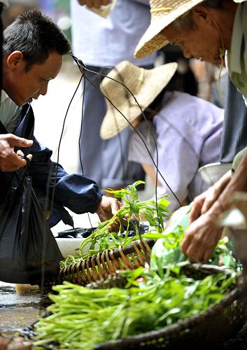 9月30日,一位文昌市民在市場(chǎng)買菜。新華社記者 郭程 攝