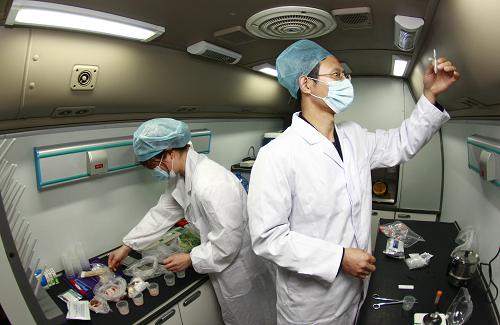 4月28日,上海出入境檢驗(yàn)檢疫局的工作人員在檢測(cè)車內(nèi)對(duì)機(jī)場(chǎng)內(nèi)的抽查食品進(jìn)行快速檢測(cè)。新華社記者 裴鑫 攝