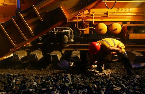 7月11日,成都鐵路局成都工務(wù)機(jī)械段施工人員在成渝鐵路雙鳳驛至椑木鎮(zhèn)區(qū)間協(xié)助拋碴車進(jìn)行清篩作業(yè)。新華社發(fā)(薛玉斌 攝)