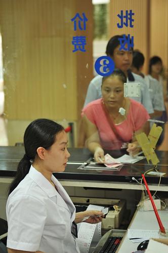 江西省南昌縣人民醫(yī)院,病人家屬在醫(yī)院財(cái)務(wù)處繳費(fèi)、報(bào)銷(攝于8月9日)。新華社記者 周密 攝