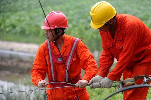 7月7日,宣城市宣州區(qū)電力施工人員冒著高溫在文昌鎮(zhèn)東梅村田間進行電路改造和升級。連日來的高溫天氣,造成安徽多處地區(qū)城鄉(xiāng)用電量急劇上升,電網(wǎng)負荷不斷加大。安徽省電力部門啟動高溫氣候下的迎峰度夏緊急預案,全力保障群眾生產(chǎn)生活用電。新華社記者 王雷 攝
