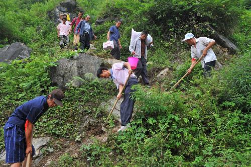 7月12日,“抗洪別動(dòng)隊(duì)”隊(duì)員們正在用鋤頭開辟山路,方便村民出入。遭受特大暴雨襲擊以來,一支由黨員干部帶頭、群眾自發(fā)參與的“抗洪別動(dòng)隊(duì)”活躍在貴州省道真仡佬族苗族自治縣玉溪鎮(zhèn)大路村。災(zāi)害發(fā)生后,大陸村大路組組長(zhǎng)、共產(chǎn)黨員周德興帶領(lǐng)16位村民組成“抗洪救災(zāi)自愿服務(wù)隊(duì)”,用自家的摩托車、汽車為受災(zāi)村民送去救濟(jì)糧、棉被、衣物,為村民打開通往村外的道路。截至目前,他們已為村民送去救濟(jì)糧2000多斤、開辟山路數(shù)百米。新華社記者 劉續(xù) 攝