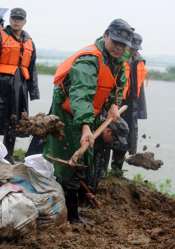 7月13日,駐守堤岸的武警官兵在破圩現(xiàn)場搶險。當(dāng)日,安徽省懷寧縣長江支流泥塘溝河堤岸出現(xiàn)破圩潰堤危險,威脅境內(nèi)30萬畝良田和近20萬人口的安全。駐守堤岸的百名武警官兵和當(dāng)?shù)馗刹?、群眾迅速趕到險情堤岸進(jìn)行緊急搶險,經(jīng)過幾個小時的奮戰(zhàn)最終排除險情。新華社記者 劉軍喜 攝
