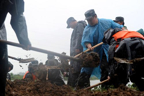 7月13日,駐守堤岸的武警官兵在破圩現(xiàn)場搶險。當(dāng)日,安徽省懷寧縣長江支流泥塘溝河堤岸出現(xiàn)破圩潰堤危險,威脅境內(nèi)30萬畝良田和近20萬人口的安全。駐守堤岸的百名武警官兵和當(dāng)?shù)馗刹?、群眾迅速趕到險情堤岸進(jìn)行緊急搶險,經(jīng)過幾個小時的奮戰(zhàn)最終排除險情。新華社記者 劉軍喜 攝