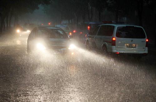 7月14日,車輛在九江街頭冒雨前行。自13日中午開始,江西九江市區(qū)遭受暴雨襲擊,據(jù)江西省氣象部門發(fā)布的信息,7月13日12時至14日12時,江西九江市區(qū)的累計降雨量達到106毫米,部分地區(qū)內(nèi)澇嚴(yán)重,給交通和市民生活帶來不便。新華社發(fā)(李濤淵 攝)
