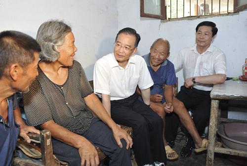 7月24日,中共中央政治局常委、國(guó)務(wù)院總理溫家寶在安徽檢查指導(dǎo)淮河防汛抗洪工作。這是溫家寶在王家壩鎮(zhèn)和諧村郎樓莊臺(tái)70多歲的王文生家聊家常。新華社記者 黃敬文 攝