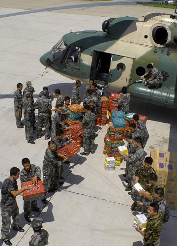 沈陽(yáng)軍區(qū)某陸航團(tuán)官兵向直升機(jī)上裝載食品(7月30日攝)。7月30日,吉林省安圖縣告急:因水災(zāi)造成部分災(zāi)區(qū)食物短缺。已連續(xù)奮戰(zhàn)兩天的沈陽(yáng)軍區(qū)某陸團(tuán)99748號(hào)、99757號(hào)機(jī)組顧不上休整,緊急出動(dòng)增援,先后向安圖縣新興鄉(xiāng)、萬(wàn)寶鎮(zhèn)等地投送食品、飲用水、消毒液10余噸,帳篷100頂,有效地緩解了災(zāi)區(qū)民眾飲食、居住等生活困難。新華社發(fā)(姜和春攝)