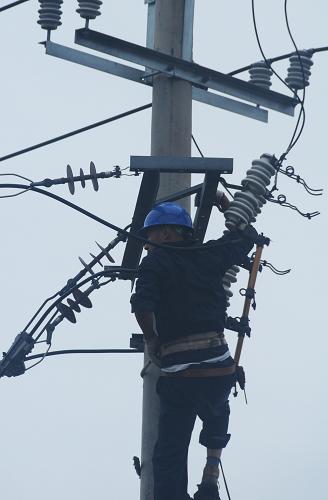 7月31日,電力工人在搶修斷電設(shè)備。洪災(zāi)過(guò)后的吉林省永吉縣城內(nèi)出線(xiàn)大面積停電,洪水剛剛退去,當(dāng)?shù)仉娏Σ块T(mén)就開(kāi)始搶修設(shè)備,確保居民能夠盡快用上電。新華社記者 宗巍 攝