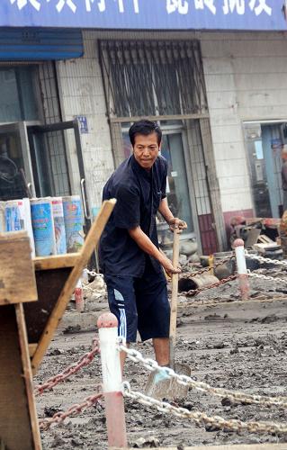 7月31日,一位居民在清理家門(mén)前的淤泥。洪災(zāi)過(guò)后,吉林省永吉縣開(kāi)始重建工作。由于受災(zāi)嚴(yán)重,很多居民家中留下大量淤泥,清理工作十分困難。居民們?cè)谝揽空仍耐瑫r(shí),也積極開(kāi)始自救,紛紛回到家中整理物品,找飲用水源、清理淤泥。新華社記者 宗巍 攝