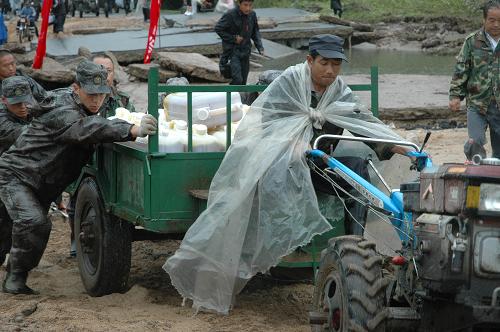 7月31日,沈陽軍區(qū)某部救援官兵在幫助受災(zāi)嚴(yán)重的安圖縣萬寶鎮(zhèn)村民運(yùn)送救援物資。當(dāng)日,隨著吉林省安圖縣萬寶鎮(zhèn)洪水有所減退,250名解放軍官兵為這座“孤島”打通了生命補(bǔ)給線,共向該鎮(zhèn)運(yùn)送60噸救災(zāi)物資,確保當(dāng)?shù)厥転?zāi)群眾使用10天左右。受連日暴雨影響,吉林省安圖縣境內(nèi)大沙河河水漫堤,多條鄉(xiāng)鎮(zhèn)公路被大水沖毀,萬寶鎮(zhèn)等地一度成為“孤島”。新華社記者 王猛 攝