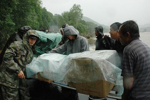 7月31日,沈陽軍區(qū)某部救援官兵在幫助受災(zāi)嚴(yán)重的安圖縣萬寶鎮(zhèn)村民運(yùn)送救援物資。當(dāng)日,隨著吉林省安圖縣萬寶鎮(zhèn)洪水有所減退,250名解放軍官兵為這座“孤島”打通了生命補(bǔ)給線,共向該鎮(zhèn)運(yùn)送60噸救災(zāi)物資,確保當(dāng)?shù)厥転?zāi)群眾使用10天左右。受連日暴雨影響,吉林省安圖縣境內(nèi)大沙河河水漫堤,多條鄉(xiāng)鎮(zhèn)公路被大水沖毀,萬寶鎮(zhèn)等地一度成為“孤島”。新華社記者 王猛 攝