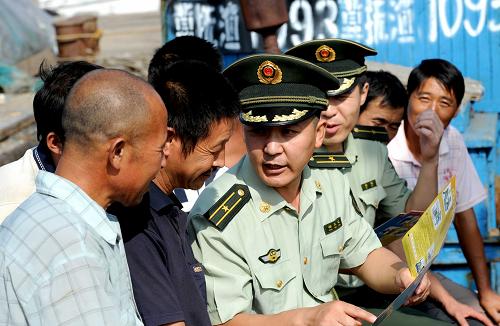 8月9日,秦皇島市卸糧口邊防派出所民警楊文江(左三)在漁船上給漁民群眾講解漁船火災(zāi)的預(yù)防知識(shí)及自救方法。8月以來(lái),針對(duì)天氣干燥、休漁期漁船集中在碼頭易發(fā)生火災(zāi)事故等情況,河北省秦皇島市公安邊防支隊(duì)所屬各派出所積極開(kāi)展“消防安全送船頭”活動(dòng),向漁民群眾宣傳消防知識(shí),以提高漁民的消防安全意識(shí)和自救能力,預(yù)防和減少漁船火災(zāi)事故發(fā)生。新華社記者 楊世堯 攝