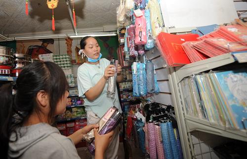 8月11日,宏源超市職工在整理商品。位于舟曲縣政府門前的宏源超市8月10日正式恢復(fù)營業(yè),這是發(fā)生泥石流災(zāi)害以來舟曲縣城重新開張的第一家超市。宏源超市擁有15個直營店,是舟曲縣城最大的連鎖零售商店。在泥石流災(zāi)害中,宏源超市有7名職工全家遇難,目前堅持上班的職工中也有多人家里有親人失蹤或遇難。新華社記者 聶建江 攝