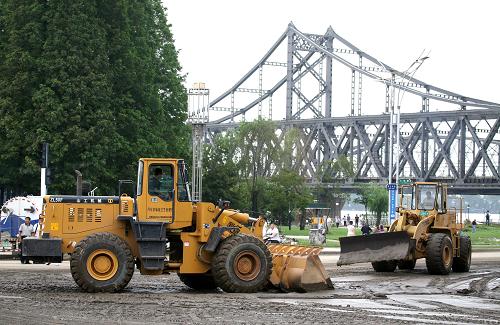 8月23日,鏟車(chē)在遼寧丹東市中朝友誼橋附近的濱江路段清除淤泥。當(dāng)日,遼寧丹東市駐軍官兵、消防人員、環(huán)衛(wèi)工人和群眾志愿者等聯(lián)合行動(dòng),對(duì)5.5公里濱江路段的過(guò)洪淤泥進(jìn)行大規(guī)模清除,確保道路安全暢通,使人們生產(chǎn)、生活盡快恢復(fù)正常。8月19日至21日,鴨綠江丹東段發(fā)生特大洪水,造成丹東市區(qū)濱江路段被江水淹沒(méi)、道路阻斷。新華社發(fā)(戚萬(wàn)鵬 攝)