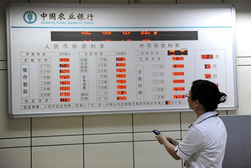 10月20日,海南省瓊海市一家農(nóng)業(yè)銀行的職員在調(diào)整存款利率展示牌。中國(guó)人民銀行19日晚間宣布,自2010年10月20日起上調(diào)金融機(jī)構(gòu)人民幣存貸款基準(zhǔn)利率。其中,金融機(jī)構(gòu)一年期存款基準(zhǔn)利率上調(diào)0.25個(gè)百分點(diǎn),由現(xiàn)行的2.25%提高到2.50%;一年期貸款基準(zhǔn)利率上調(diào)0.25個(gè)百分點(diǎn),由現(xiàn)行的5.31%提高到5.56%;除活期存款利率未調(diào)整外,其他各檔次存貸款基準(zhǔn)利率均相應(yīng)調(diào)整。這是我國(guó)央行時(shí)隔3年后的首度加息。新華社發(fā)(蒙鐘德 攝)