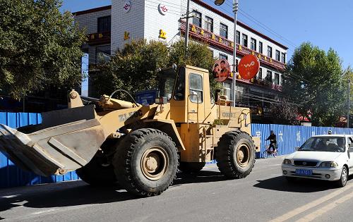 10月25日,一輛挖掘機(jī)進(jìn)入北京中路一施工現(xiàn)場。北京中路是橫貫拉薩東西的最主要街道,該路改造工程全長1.28公里。日前,拉薩市部分道路進(jìn)行改造工程,改造內(nèi)容包括道路、給排水、路燈、景觀綠化、管線入地等項(xiàng)目,預(yù)計(jì)將于2011年4月完工。屆時(shí),拉薩市城市功能將更加完善。新華社記者 覺果 攝