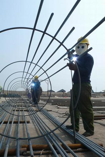 這是2009年10月4日,建設(shè)者在河北省滄州市沿海高速公路青鋒農(nóng)場互通樞紐工程工地施工。滄州市沿海高速公路連接天津和山東,將把環(huán)渤海港口與城市群串聯(lián)起來。新華社發(fā)