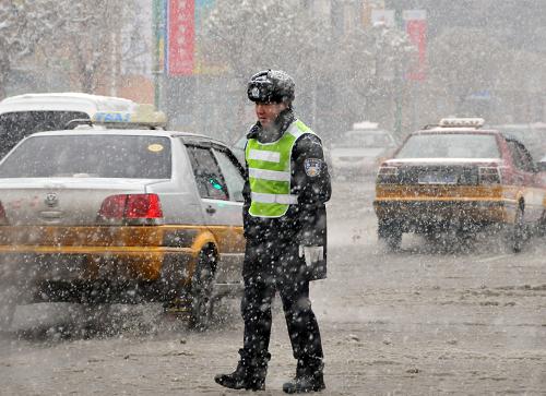 11月13日,長(zhǎng)春市一名交警在冒雪指揮交通。從11月12日夜開始,吉林省出現(xiàn)暴雪天氣,各地公路交通受到嚴(yán)重影響,部分高速公路臨時(shí)關(guān)閉,大量長(zhǎng)途客運(yùn)汽車停運(yùn),長(zhǎng)春龍嘉國(guó)際機(jī)場(chǎng)也已關(guān)閉。長(zhǎng)春市公安局交警支隊(duì)啟動(dòng)惡劣天氣紅色應(yīng)急預(yù)案,全體外勤人員上崗指揮交通。新華社記者 齊海山 攝