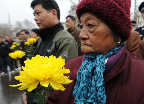 12月13日,大屠殺幸存者仇秀英老人(右)參加在“侵華日軍南京大屠殺中山碼頭遇難同胞紀(jì)念碑”前舉行的悼念儀式。當(dāng)日,南京各界群眾集會(huì)悼念侵華日軍南京大屠殺30萬(wàn)同胞遇難73周年。在南京下關(guān)“侵華日軍南京大屠殺中山碼頭遇難同胞紀(jì)念碑”前的分會(huì)場(chǎng),來(lái)自各單位和街道社區(qū)的機(jī)關(guān)干部、市民群眾、部隊(duì)官兵及大屠殺幸存者代表一同舉行悼念儀式,憑吊遇難同胞。新華社記者 孫參 攝