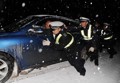 1月18日凌晨,貴州丹寨幾名交警在風雪中合力推動打滑的車輛前行。當日,受強冷空氣影響,貴州省丹寨縣下起了中到大雪,境內(nèi)多處公路路段出現(xiàn)嚴重的雪凝現(xiàn)象,影響過往車輛行駛安全。丹寨縣交警部門立即啟動雪凝災害應急預案,不分晝夜在各條線路進行巡查,指揮引導車輛安全通行。新華社發(fā)(黃曉海 攝)