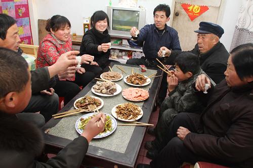 1月26日,平學(xué)民(左五)一家人在吃團(tuán)圓飯,過(guò)小年。新華社發(fā)(孫樹(shù)寶 攝)
