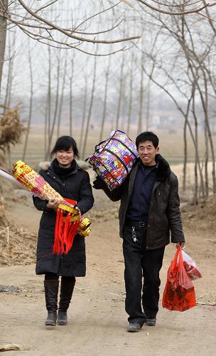 1月26日,平學(xué)民和女兒平魏楠帶著采購(gòu)的年貨走在村口。新華社發(fā)(孫樹(shù)寶 攝)