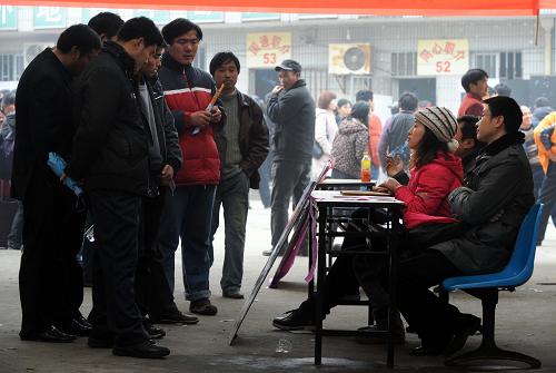 2月8日,求職者在市場(chǎng)內(nèi)的用人單位招工攤位前了解崗位及待遇情況。當(dāng)日,南京最大的外來工勞務(wù)市場(chǎng)——安德門民工就業(yè)市場(chǎng)結(jié)束春節(jié)休假,重新開市。市場(chǎng)內(nèi)各職介機(jī)構(gòu)備有1萬多個(gè)工作崗位投入招聘,來自各地的大約2000名民工進(jìn)場(chǎng)求職。新華社記者 孫參 攝