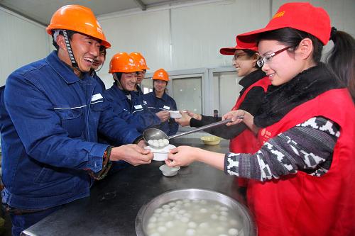 2月16日,志愿者張潔(右一)將熱騰騰的元宵盛給進城務工人員王偉(左一)。當日,安徽省馬鞍山市“黃綠紅”電力志愿者們來到該市220千伏金山變電站建設現(xiàn)場,與將在外度過元宵佳節(jié)的變電站建設者、進城務工人員一起聯(lián)歡、做湯圓、吃湯圓,喜迎元宵佳節(jié)的到來。新華社發(fā)(陶洋攝)