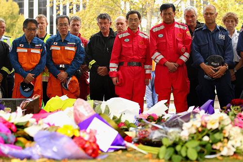 3月1日,兩名中國救援隊(duì)隊(duì)員(紅衣)與各國救援隊(duì)員一起在新西蘭克賴斯特徹奇市中心大教堂前為地震死難者默哀。新西蘭全國各地的民眾以及正在當(dāng)?shù)氐母鲊仍?duì)員于當(dāng)?shù)貢r(shí)間1日中午12時(shí)51分默哀兩分鐘,哀悼地震中的遇難者。新華社發(fā)