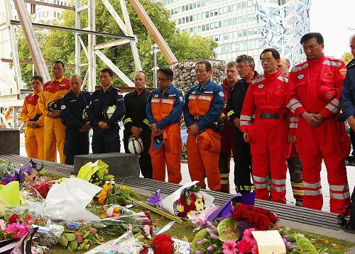3月1日,兩名中國救援隊(duì)隊(duì)員(紅衣)與各國救援隊(duì)員一起在新西蘭克賴斯特徹奇市中心大教堂前為地震死難者默哀。新西蘭全國各地的民眾以及正在當(dāng)?shù)氐母鲊仍?duì)員于當(dāng)?shù)貢r(shí)間1日中午12時(shí)51分默哀兩分鐘,哀悼地震中的遇難者。新華社發(fā)