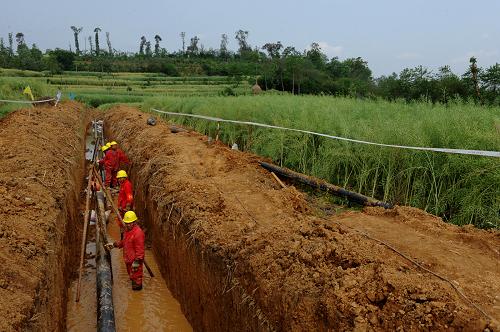 5月2日,中國石化西南石油局油田建設(shè)工程公司職工在四川綿陽安縣塔水鎮(zhèn)進行德陽至新北川的天然氣管線鋪設(shè)工作。四川德陽至新北川天然氣管線工程是西南油氣田的災(zāi)后重建項目,管道全長62千米,日輸氣能力為40萬立方米,包括改擴建站場2座,新建站場1座,預(yù)計今年6月完工供氣。新華社發(fā)(胡慶明 攝)